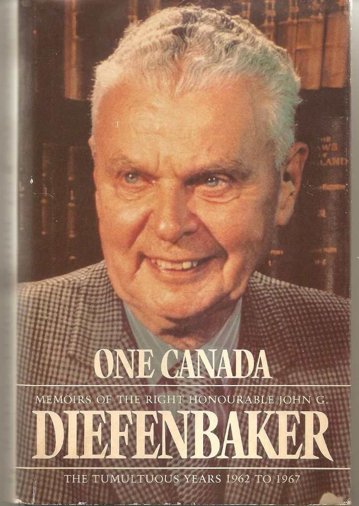 Close-up of a smiling older man with light hair, wearing a checkered suit, against a backdrop of bookshelves, featuring the book cover titled 'One Canada' by John G. Diefenbaker.