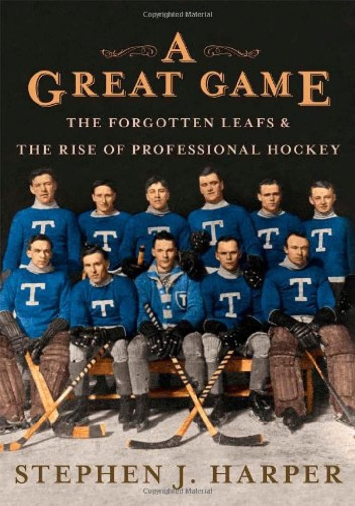 Book cover of 'A Great Game: The Forgotten Leafs & The Rise of Professional Hockey' by Stephen J. Harper featuring a historic hockey team in blue uniforms posing with hockey sticks.